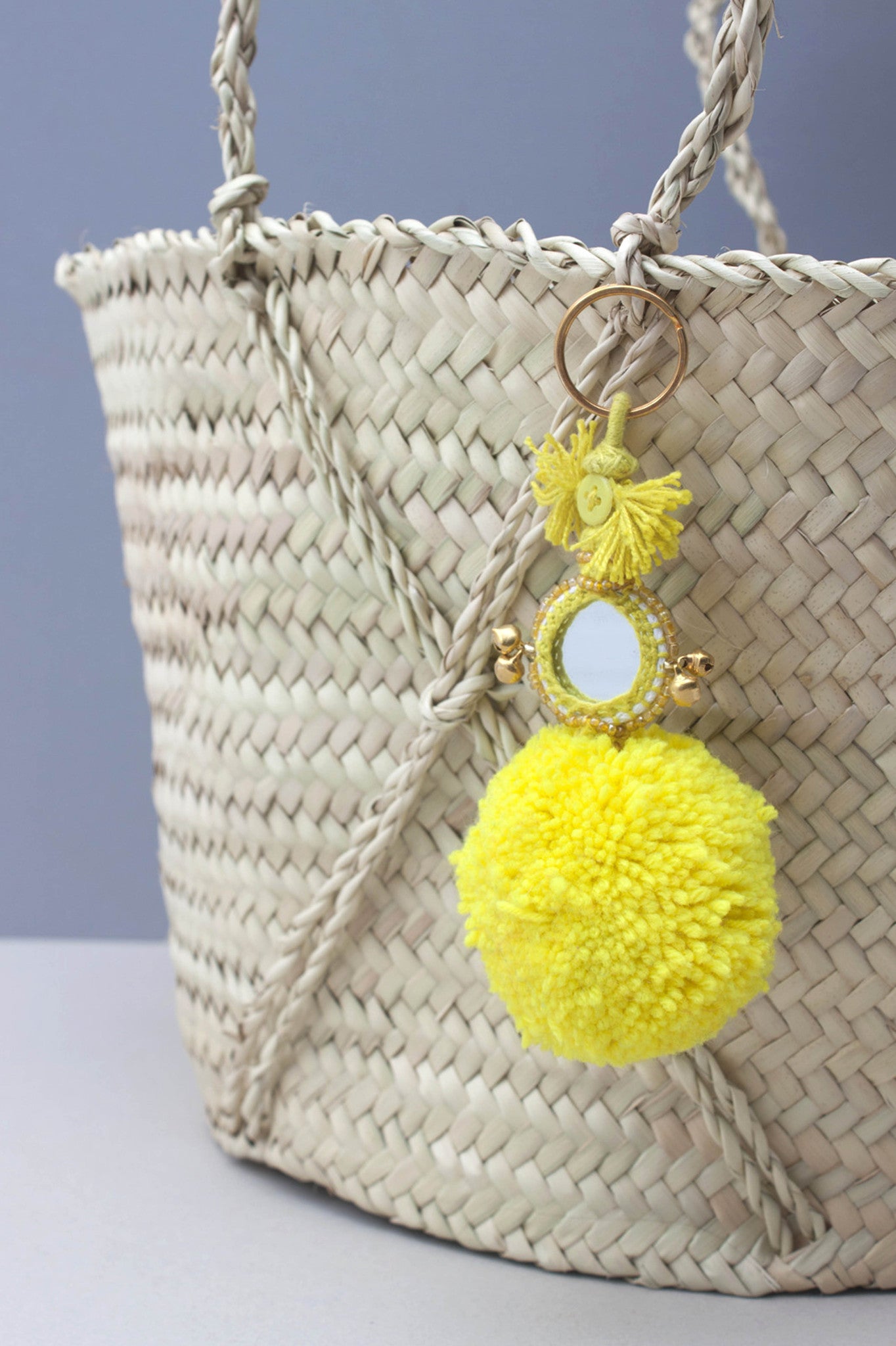 The Pom Pom Mirror Keyring by Bohemia Design is a bright wool pom pom embellished with colorful decorated mirrors, beads and bells -- handmade in India by artisans. This eye-catching pom pom keyring adds a fun twist to your everyday routine. Available in Navy Jade Green Purple Red Yellow Orange Pink Ivory Grey Azure Black  100% Wool Pom Pom Measurements 6" L