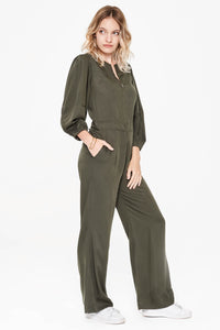 Sitting Pretty Fall 2018 Lila Panelled Jumpsuit in Hunter. Flared leg jumpsuit featuring cropped tapered sleeves and a slight drop waist. Round neckline with front and back yoke. Front zip closure. Gathered shoulder with wide cuff. Slant pockets. Regular fit. Made in South Africa. Color green. 100% rayon twill. Sizes small medium large.