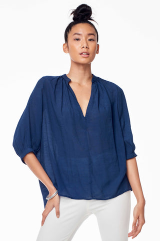 Accompany Exclusive Sitting Pretty Asmara Top in Carbon. Loose oversized blouse with gathered split V-neckline, three quarter sleeve, gathering at back panel, dipped curved back hem. Pull over style. Measures 24 inches from shoulder to hem. Color navy. 100% ghost chiffon. Sizes Small Medium Large.