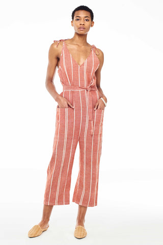 Wax and Cruz Spring 2018 Cabiria Jumpsuit in Rust Stripe. Soft handwoven cotton and sexy shoulder ties. V-neckline with removable matching tie wasit belt. Loose fitting with front patch pockets on trouser. Ankle crop. Unlined. Small/Medium measures 50.5 inches from shoulder to hem. Color red and white stripe. 100% cotton. Sizes Small/Medium Medium/Large.