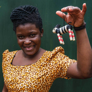 Ugandan artisan holding a raffia ornament