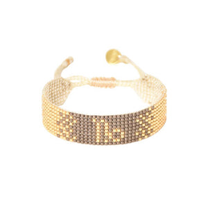 Capricorn gold and tan beaded bracelet with a tie closure, handmade by artisans in Colombia