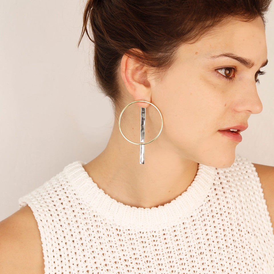 Accompany Exclusive Soko Compass Earring. Jacket hoop earring. Cast brass hoop. Chrome plated silver bar jacket. 2 inch diameter hoop. 3 inch drop from post. Post setting for pierced ears. Color gold silver. Brass, chrome plating. One size.